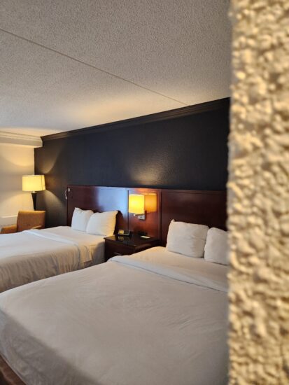 Chambre 2 Lits Queen – un hébergement spacieux et confortable avec deux lits Queen-size, un accès direct au stationnement par la porte-patio, idéal pour les familles et les motoneigistes.