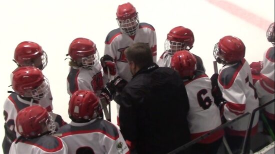 Équipe sportive en uniforme se préparant pour un match, idéale pour un séjour à l’Hôtel La Saguenéenne.