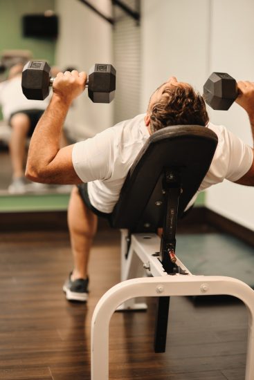Personne effectuant des exercices de musculation dans le centre d'entraînement de l'Hôtel La Saguenéenne.