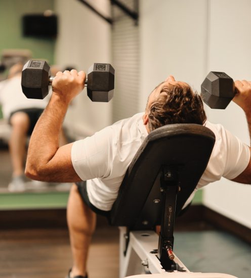 Personne effectuant des exercices de musculation dans le centre d'entraînement de l'Hôtel La Saguenéenne.