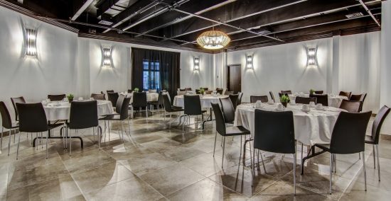 "Salle Rivière à Mars: espace élégant avec tables rondes, chaises modernes, éclairage contemporain et configuration modulable pour événements d'affaires et banquets au Restaurant Tomahawk Saguenay