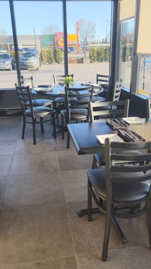 Terrasse avec fenêtres panoramiques du restaurant à Chicoutimi, parfait pour le petit-déjeuner et la planification de la journée.