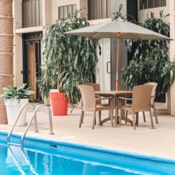 Table près de la piscine avec vue sur le jacuzzi à l'hôtel La Saguenéenne