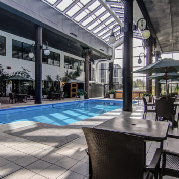 Table près de la piscine avec vue sur le jacuzzi à l'hôtel La Saguenéenne