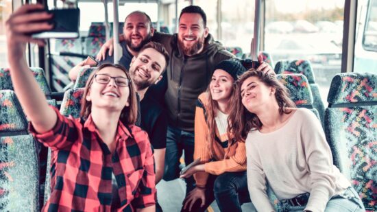 Un groupe d’adolescents dans un autobus, en route pour une excursion printanière à Saguenay, avec un séjour prévu à l’hôtel La Saguenéenne.