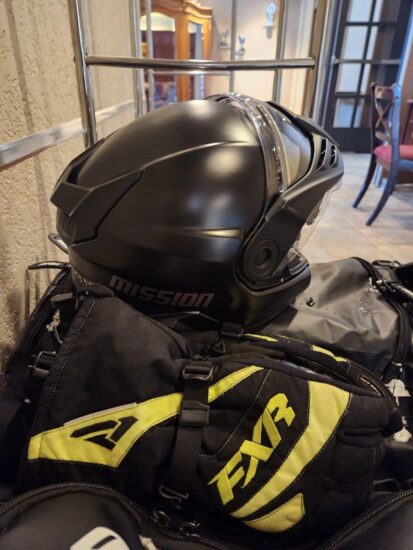 Équipement de motoneigiste sur un chariot dans le hall de l’hôtel La Saguenéenne, prêt pour l’aventure hivernale à Saguenay.