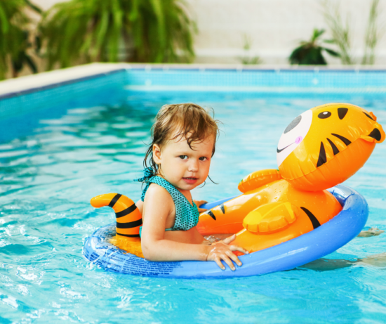 Enfant heureux jouant dans la piscine intérieure chauffée de l’hôtel à Saguenay