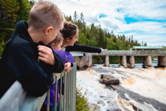Visiteur observant la nature depuis une passerelle suspendue au Parc de la caverne Trou de la Fée près de Desbiens, Saguenay.