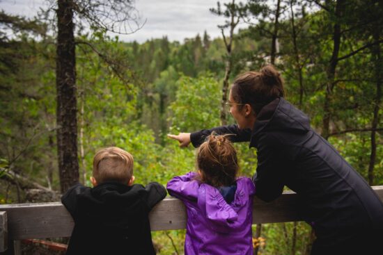 Visitor observing nature from a suspended footbridge at Trou de la Fée Cave Park near Desbiens, Saguenay.